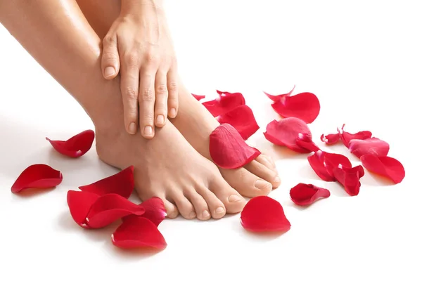 Patas femeninas, mano y pétalos rojos — Foto de Stock