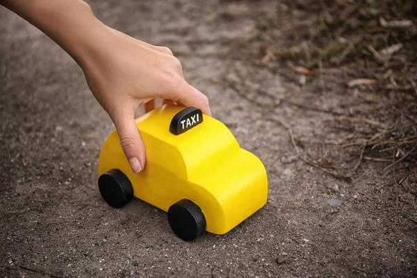 Frau mit gelbem Spielzeugtaxi — Stockfoto