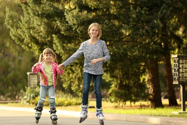 Cute girls on roller skates in park — Stock Photo, Image