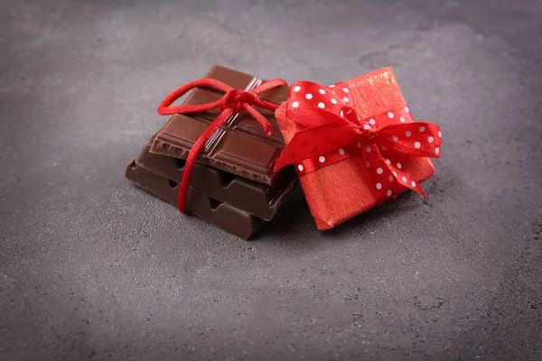 Chocolate pieces with present — Stock Photo, Image