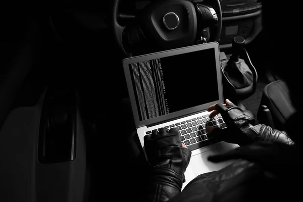 Dieb hackt Auto-Sicherheitssystem mit Laptop — Stockbild Dieb hackt Auto-Sicherheitssystem — Stockfoto