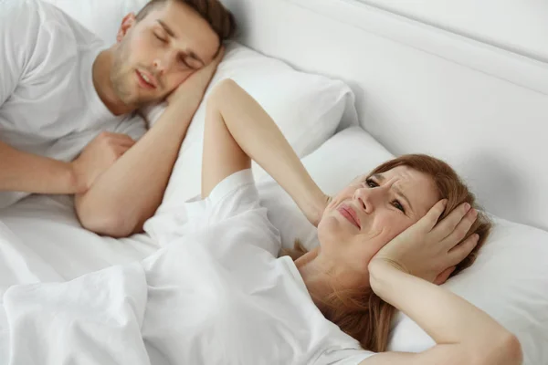 La joven no puede dormir por los ronquidos de su hombre. —  Fotos de Stock