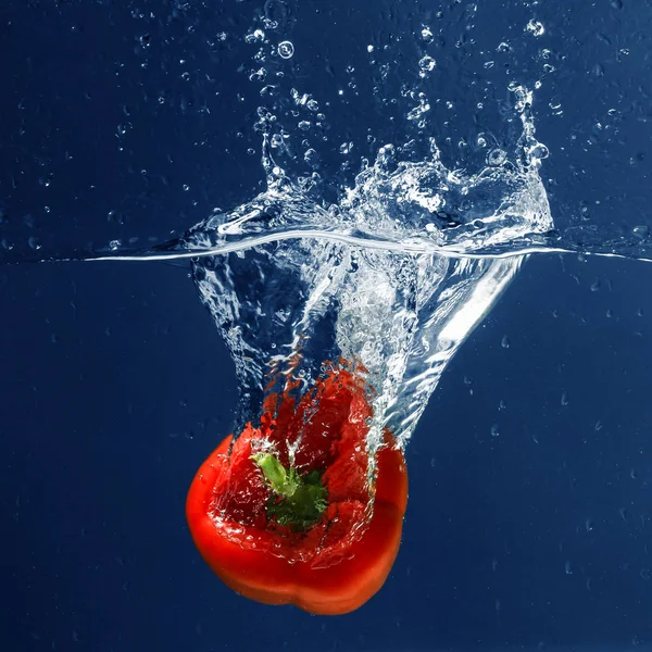 Red bell pepper falling in water — Stock Photo, Image