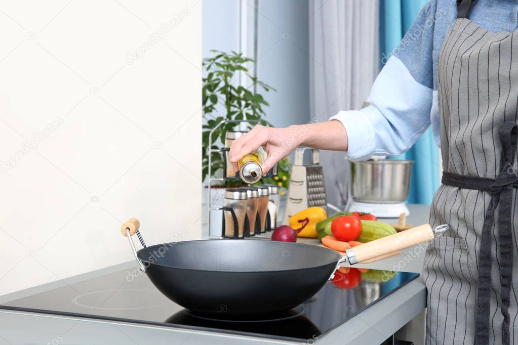 Woman pouring oil in pan