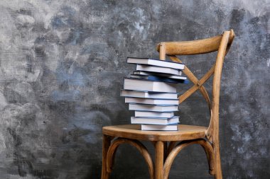 sandalye üzerinde kitap yığını 