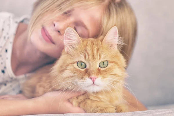 Kleines Mädchen mit roter, flauschiger Katze — Stockfoto