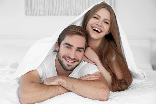 ベッドで若いかわいいカップル — ストック写真