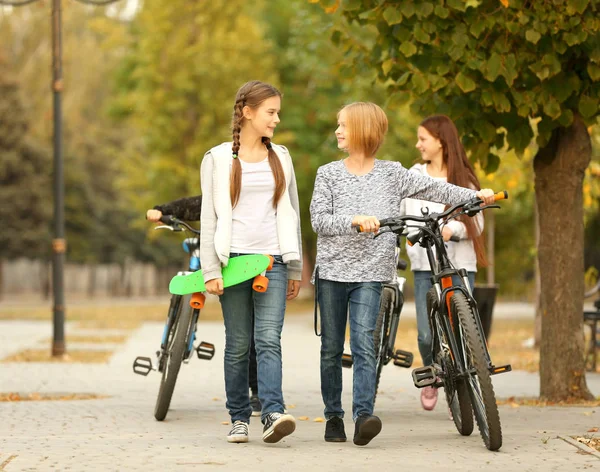 Glada vänner med cyklar i park — Stockfoto