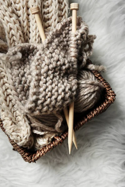 Knitting yarn and needles in wicker basket — Stock Photo, Image
