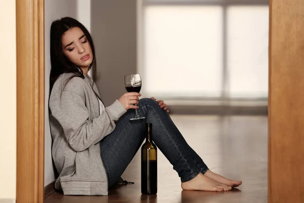 Depressed woman drinking wine
