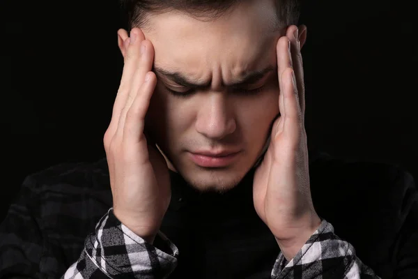 Bonito homem deprimido no fundo preto — Fotografia de Stock