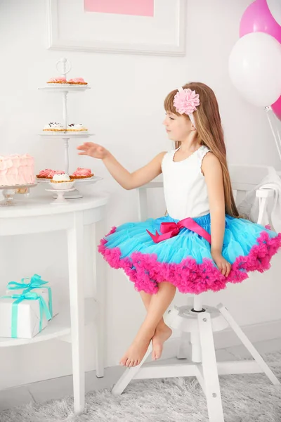 Menina bonito comer bolos saborosos — Fotografia de Stock