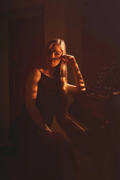 Bella donna vicino al pianoforte — Foto Stock