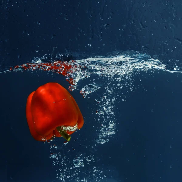 Rote Paprika fällt ins Wasser — Stockfoto