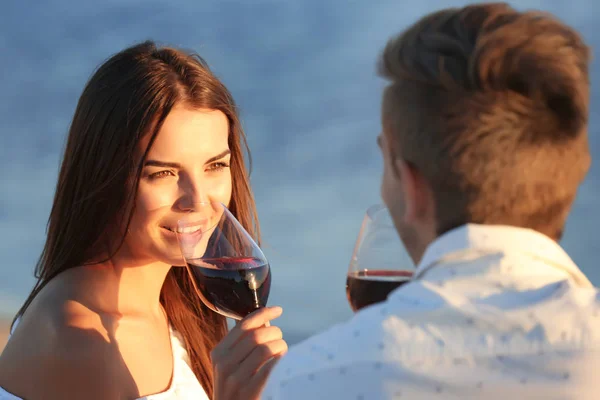 Молодая пара с вином, романтическое свидание на пляже на закате — стоковое фото
