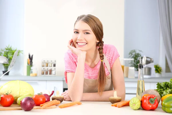 台所でさまざまな野菜を持つ若い女性 — ストック写真