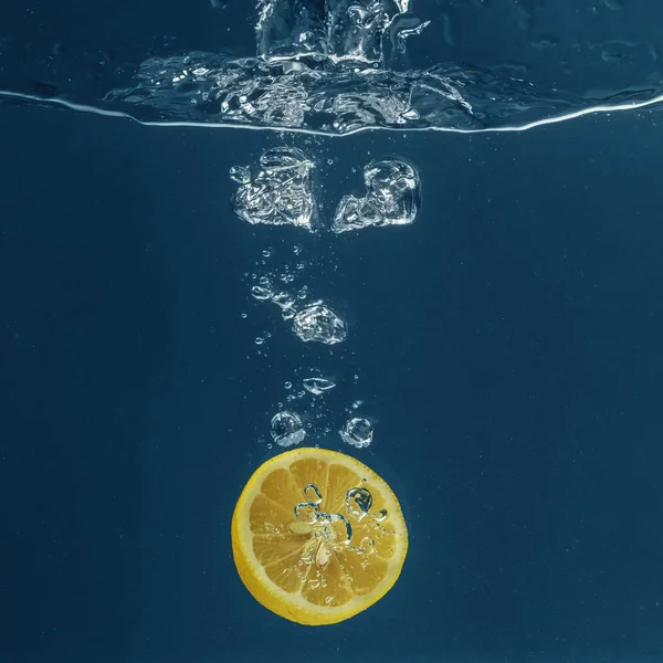 Limón cayendo en agua — Foto de Stock