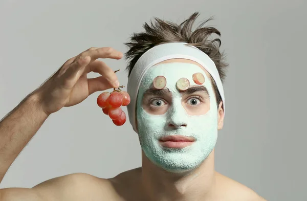 Man with cosmetic mask on face, gray background — Stock Photo, Image
