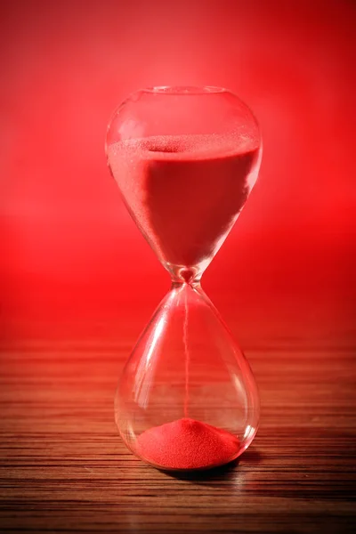 Reloj de arena de cristal con arena roja — Foto de Stock