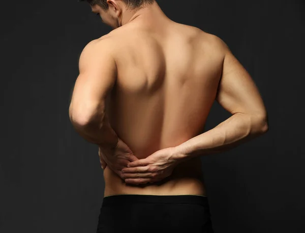 Молодой человек страдает от боли в спине — стоковое фото