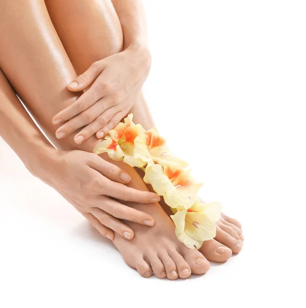 Kvinnliga ben och händer med blommor — Stockfoto