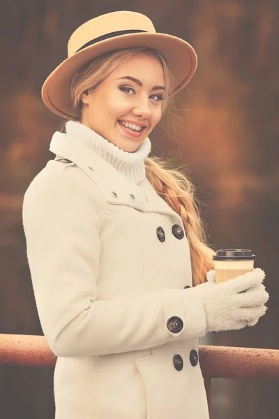Hermosa chica con café en el parque de otoño — Foto de Stock