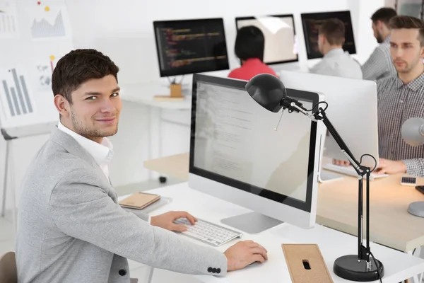 Knappe jonge programmeur werkzaam in kantoor — Stockfoto