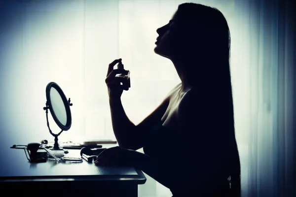 Silhouet van de vrouw met behulp van parfum — Stockfoto