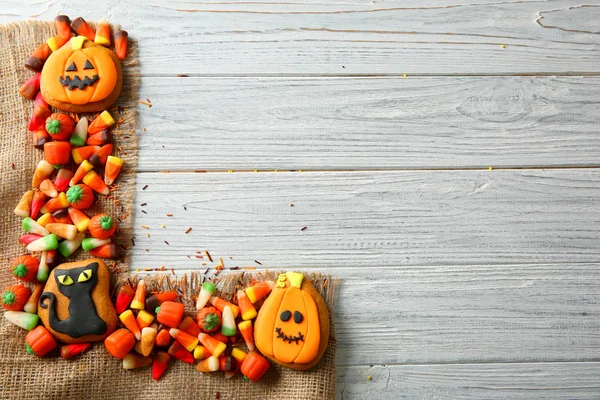 Halloween cookies and jelly sweets on wooden background — Stock Photo, Image