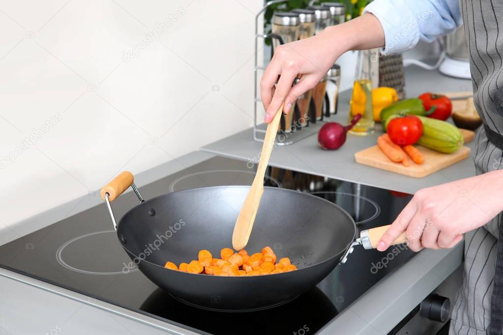 Woman mixing vegetables in pan 