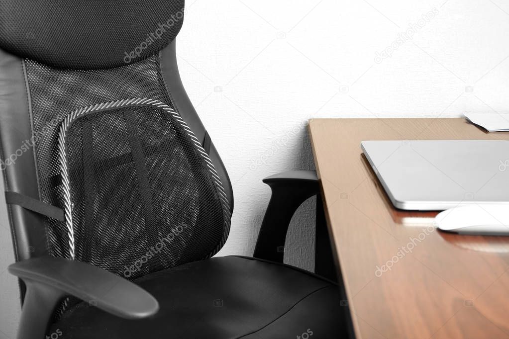 Office chair with mesh for back support  on white wall background