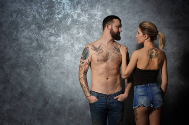Tutku güzel çift gri duvar arka plan üzerinde dövme