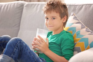 Çocuk tutan bir bardak süt 