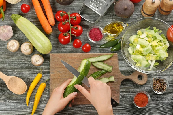 Manos femeninas pelando pepino en la mesa, vista superior — Foto de Stock