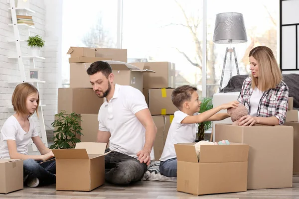 Family unpacking cardboard boxes