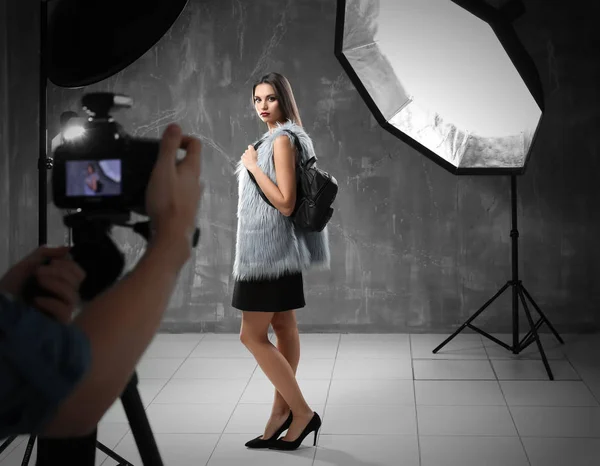 Jovem modelo bonito posando para fotógrafo profissional em estúdio — Fotografia de Stock