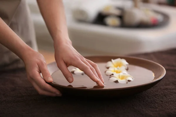 Mani femminili con ciotola e fiori — Foto Stock