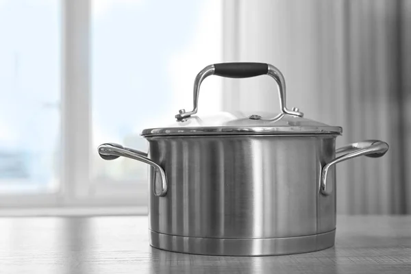 Metal saucepan on table — Stock Photo, Image
