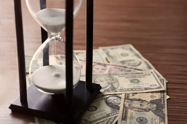 Black hourglass with money — Stock Photo, Image