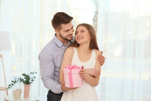 Joven hombre dando regalo a la mujer — Foto de Stock