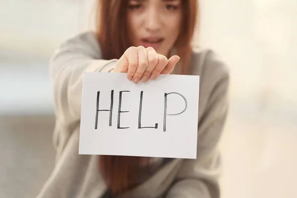 Woman holding paper with word HELP — Stock Photo, Image