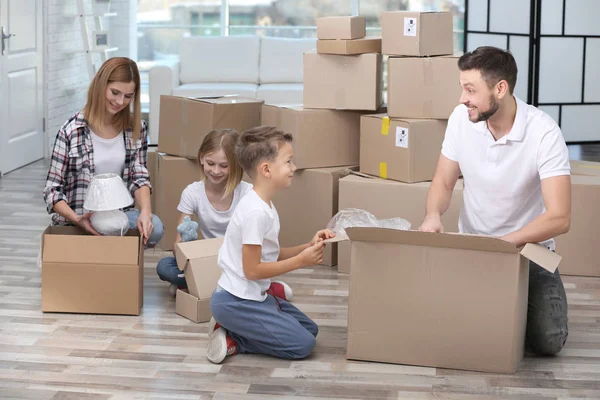 Familie packt Kartons im neuen Zuhause aus — Stockfoto