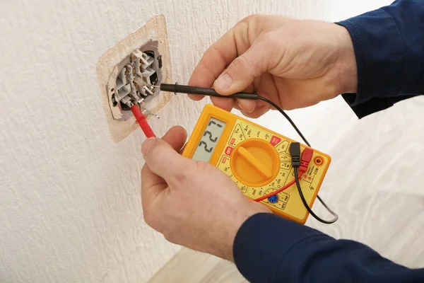 Electrician measuring voltage of socket — Stock Photo, Image