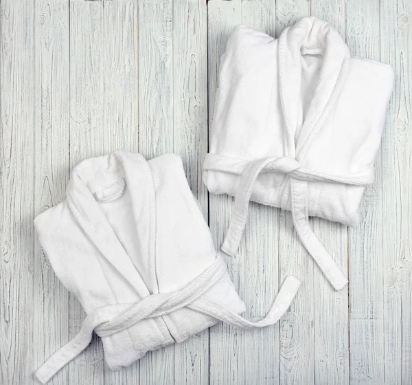 Folded spa bathrobes on wooden background — Stock Photo, Image