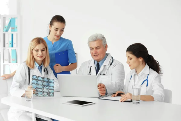 Equipo de médicos explorando roentgenograma en la mesa —  Fotos de Stock