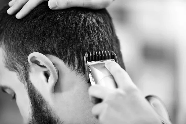 Professioneller Friseur macht stilvollen Haarschnitt für Mann, getönt in schwarz und weiß — Stockfoto