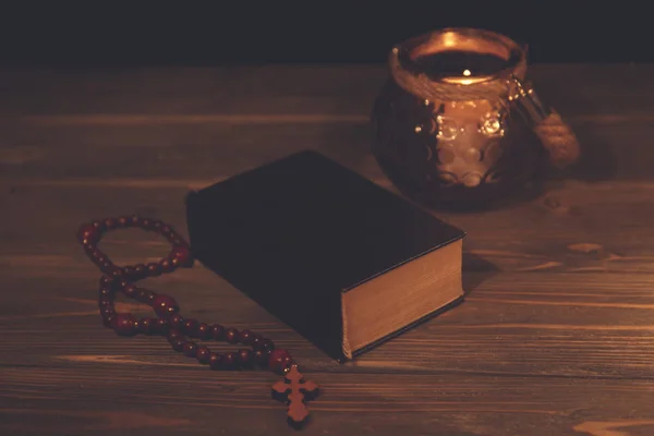 Bible with rosary on table