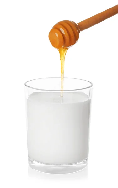 Verser du miel dans un verre de lait — Photo