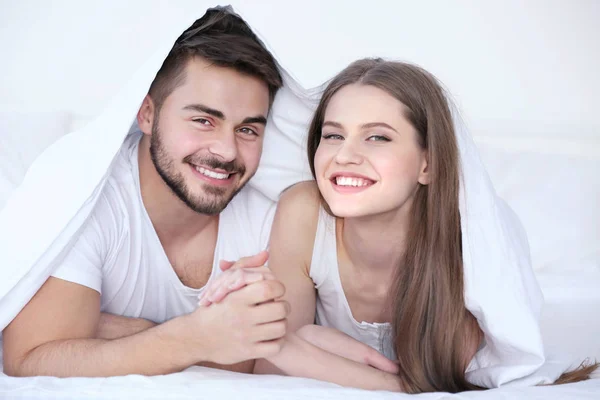 Giovane coppia sdraiata sul letto — Foto Stock
