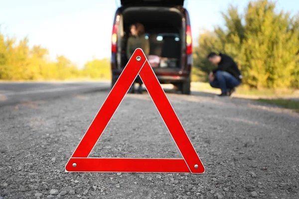 沥青路面红色警告三角形 夫妇附近的破车 — 图库照片